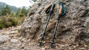 Close-up of carbon fibre trekking poles vs aluminium trekking poles resting on gritstone in the Peak District