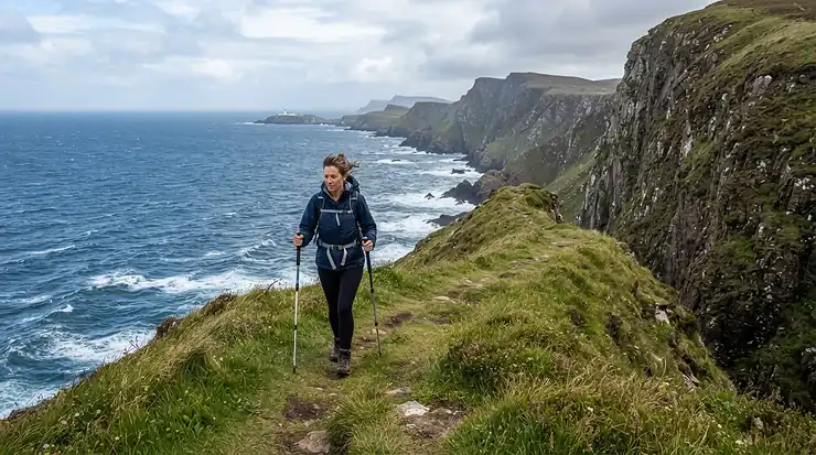 Walking enthusiast using lightweight trekking poles along a grassy coastal cliff path