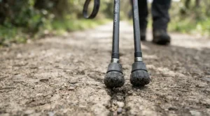 Detailed view of rubber walking tips attached to nordic walking poles on a tarmac path
